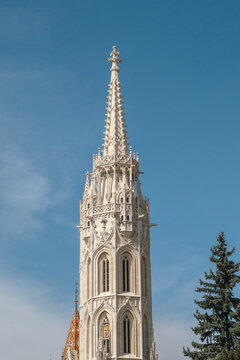 Intricate Gothic church spire reaching into clear blue sky