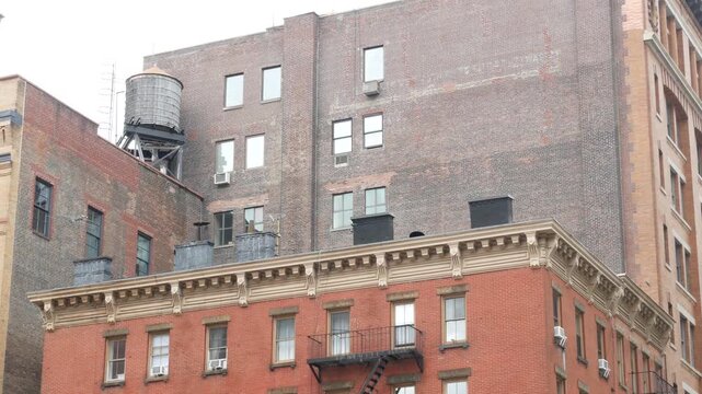 New York City urban red brick building architecture, Lower Manhattan rooftop, United States of America. Water tower on roof. Classic water tanks in Downtown. Varick street in Tribeca.