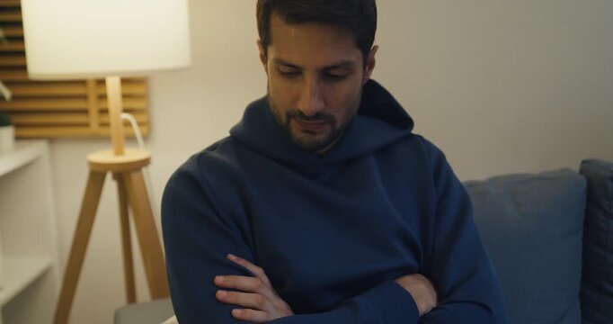 Stressed Hispanic young couple anger ignoring each other and sit apart on sofa at home night. Marriage relationship problem, domestic conflict stress, divorce crisis, communication breakdown concept.
