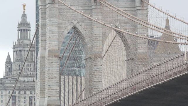 Brooklyn Bridge and Manhattan Municipal Building 1914 in Downtown from Brooklyn Dumbo, New York City Civic Center, United States. American brick architecture, famous tourist landmark. Foggy rainy day.