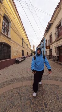 Man with Hoodie Walking Through Historic Tarija Street in Potosi Bolivia