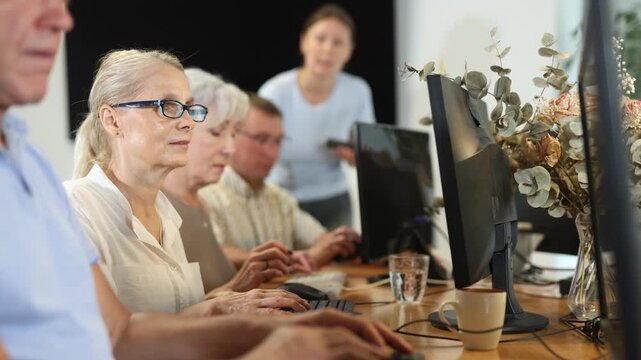 Group of elderly people learn to use computer at master class