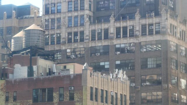 New York City Midtown urban residential building, red brown brick architecture, Manhattan rooftop, United States of America. Water tower on roof. Classic water tanks. Hells Kitchen Port Authority area