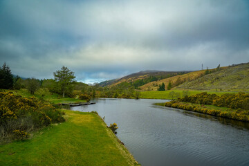 Fototapeta premium A wide, calm stretch of the Caledonian Canal—an artificial waterway in Scotland—with no locks. The Caledonian Canal is Scotland’s longest inland waterway