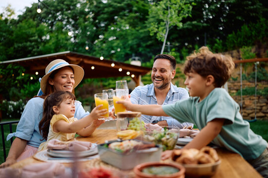 Happy family toasting while having lunch on patio.