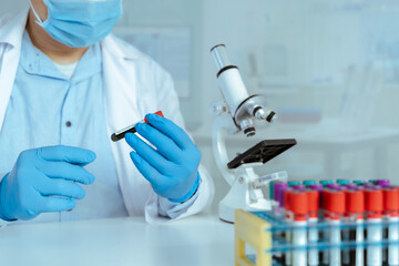 Fototapeta premium Scientist Examining Blood Sample Tube in Clinical Laboratory