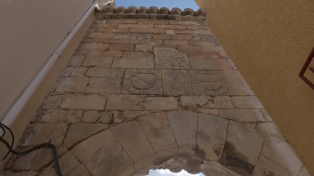The Arco de la Encarnaci&oacute;n in Pegalajar, Ja&eacute;n, showcases the intricate stonework and ancient heraldic shields embedded in the historic structure of the arch.