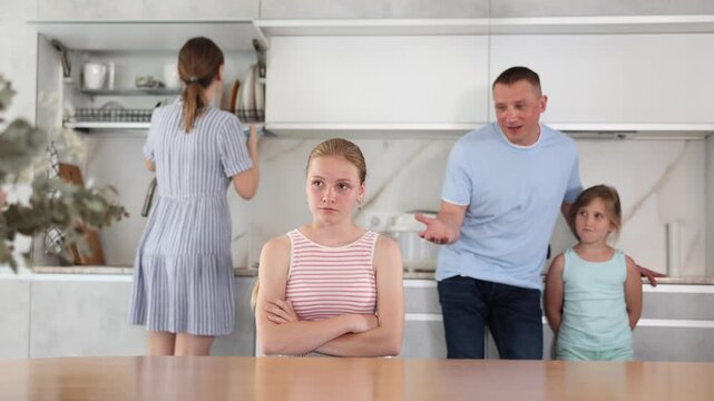 Father and mother screaming at teenager daughter in home kitchen