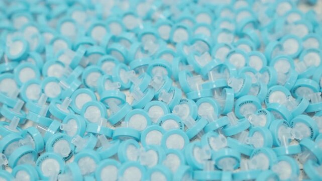 Close up footage of blue PTFE syringe filters used in laboratory sample preparation before HPLC and LC analysis. Scientific laboratory workflow, sample filtration process, analytical chemistry