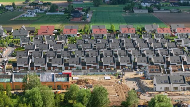 An aerial view of a newly built estate of single-family houses in rows on the outskirts of a large city, real estate market, prices and use of space by developers.