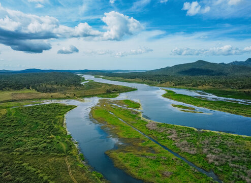 Aerial view of a winding river cutting through a lush, green landscape