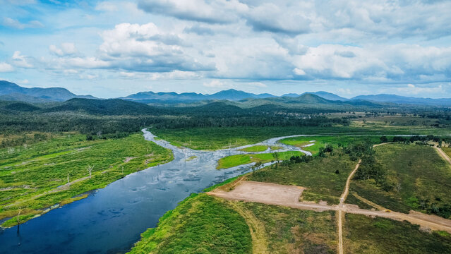Aerial view of a winding river cutting through a lush, green landscape