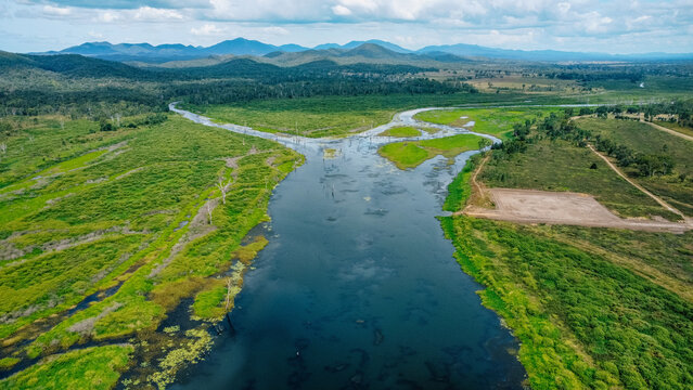 Aerial view of a winding river cutting through a lush, green landscape