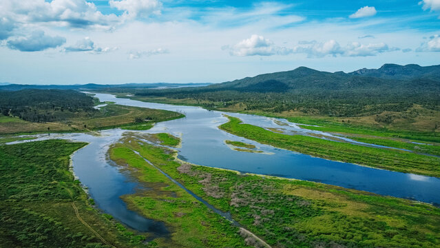 Aerial view of a winding river cutting through a lush, green landscape
