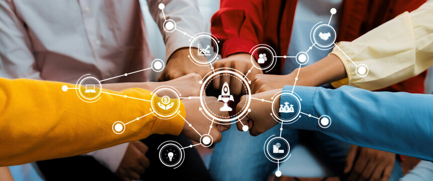 A vibrant and dynamic image capturing diverse hands joining in a fist bump above digital icons that symbolize innovation, creativity, and collaborative teamwork in a workplace setting. Amity