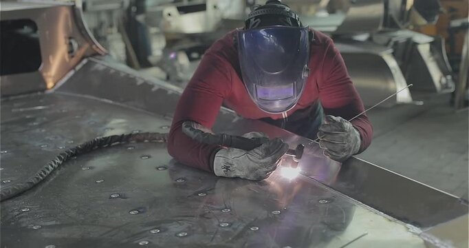 Close-up of welding an aluminum boat hull or aluminum alloys. Welders weld a RIB boat hull. Welding process in the shop. Boat production, boat manufacturing, boating industry