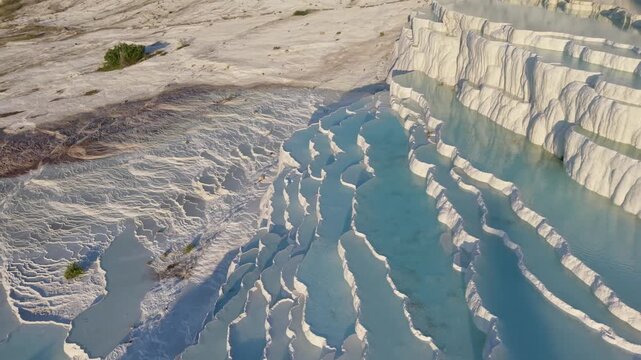 Explore the surreal travertine terraces of Pammukale in Turkey, where vibrant blue waters flow over white formations. Witness natures artistry in this unique destination, perfect for travelers.