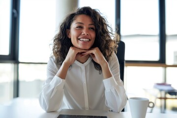 Obraz premium The woman in white blouse smiling confidently at desk in modern office