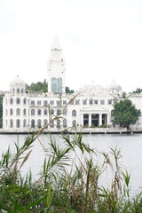 Fototapeta premium The white castle building opposite the grassland and the lake