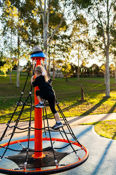 Child playing on park play equipment