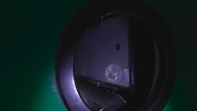 Human hand putting an empty aluminum soda can into a reverse vending machine to receive a cash deposit back, promoting responsible recycling and environmental sustainability awareness
