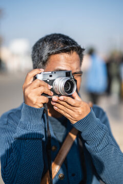 man taking picture with retro style rnge finder camera