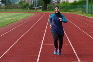 Fototapeta premium Muslim Woman Running On Outdoor Track Wearing Hijab And Sportswear For Fitness And Wellness