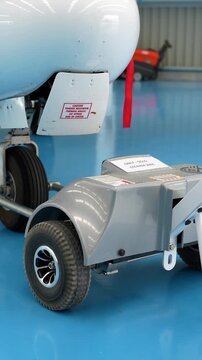Aircraft tow tractor moving private jet inside hangar