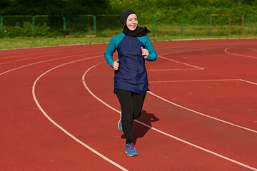 Obraz premium Muslim Woman Running on Outdoor Track in Sports Hijab Practicing Fitness and Jogging