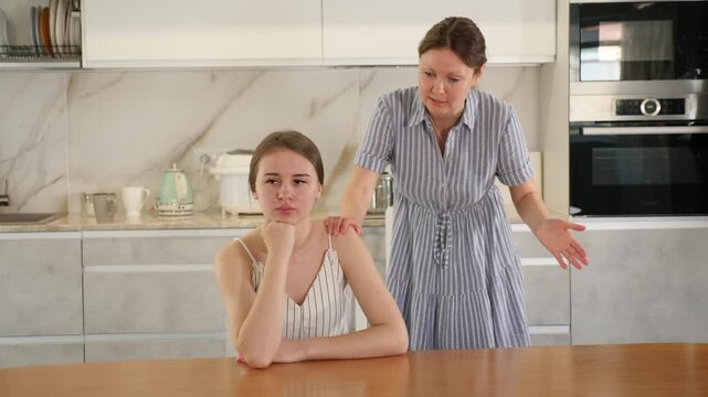 Quarrel between an mother and an adult daughter in home kitchen