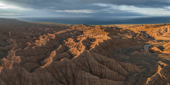 Evening mood, Canyon runs through landscape, Issyk Kul Lake, Dramatic barren landscape of eroded hills, Badlands, Canyon of the Forgotten Rivers, Issyk Kul, Kyrgyzstan