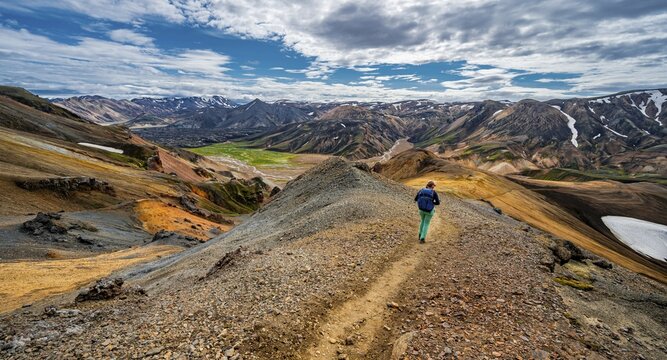 Hiker on the Laugavegur trekking trail, Laugavegur trekking trail, Dramatic volcanic landscape, Colourful erosion landscape with mountains, Lava field, Landmannalaugar, Fjallabak nature reserve, Su&eth;urland, Iceland