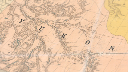 Fototapeta premium Macro View of Vintage Map Highlighting Yukon Canada with Detailed Geographic Cartography