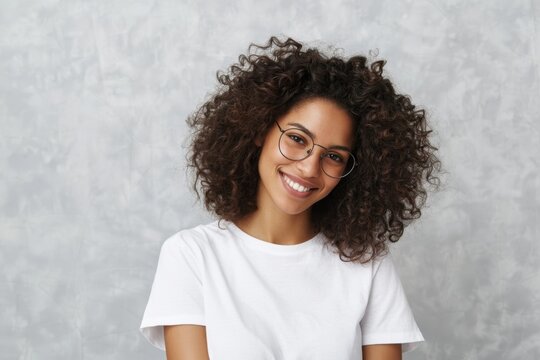 The smiling woman with curly hair and glasses in a casual white t-shirt