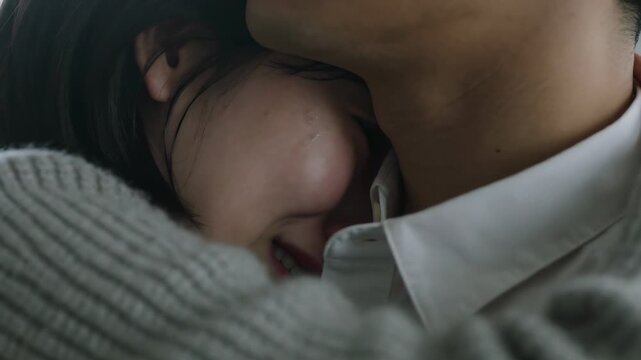Seeking comfort, woman nuzzling man's neck near window, gray knit sweater and white collared shirt