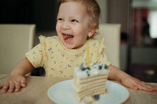 Happy girl celebrating birthday with cake at table
