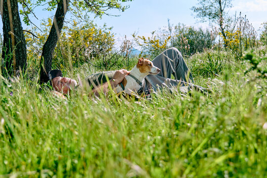 Owner and dog rest peacefully in a spring meadow
