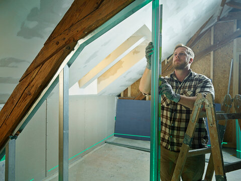 Construction worker measuring metal at site
