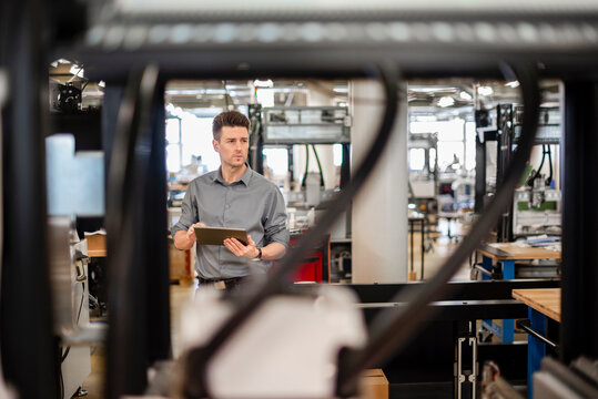 Factory manager inspecting production with digital tablet