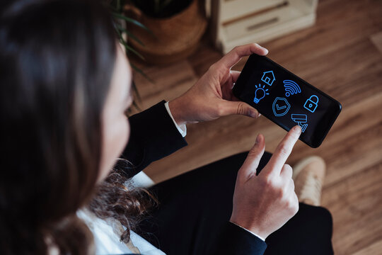 Businesswoman using home automation application on smart phone