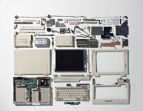 Deconstructed laptop parts arranged neatly on a white background
