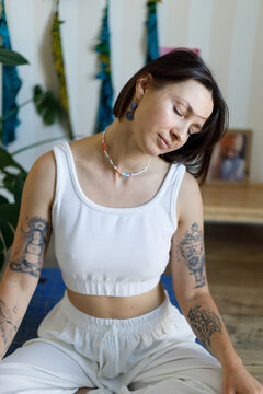 Yoga teacher stretching neck during indoor meditation practice