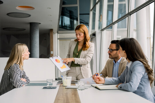 Businesswoman presenting project in office meeting with team