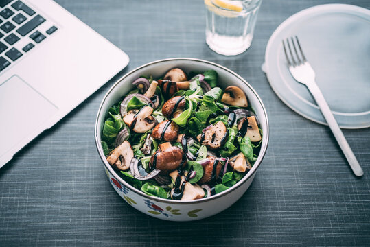Lunch box with field salad, onions, roasted mushrooms, onions and balsamico