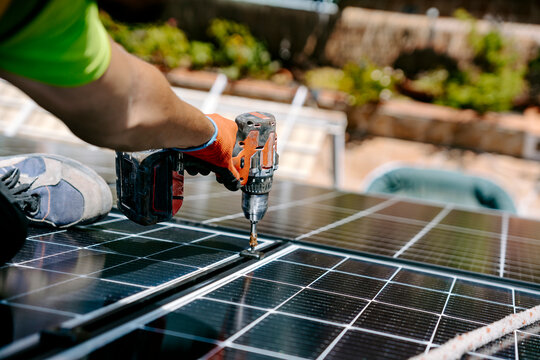 Engineer installing solar panel with drill machine