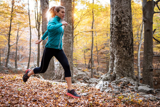 Athlete running in forest during autumn