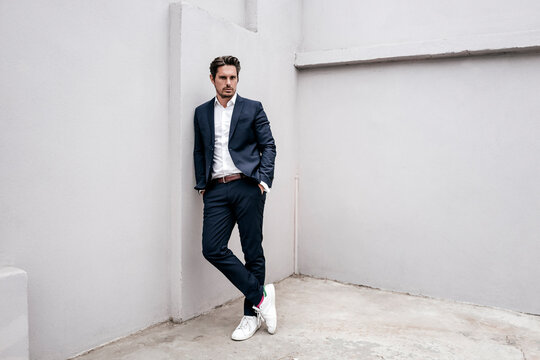 Portrait of confident businessman leaning against a wall