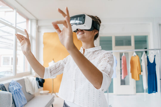 Young woman in fashion studio wearing VR glasses