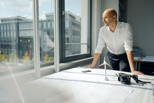Engineer working in his office with model of a wing�d wheel on his desk