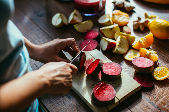 Woman's hands chopping beetroot for squeezing juice